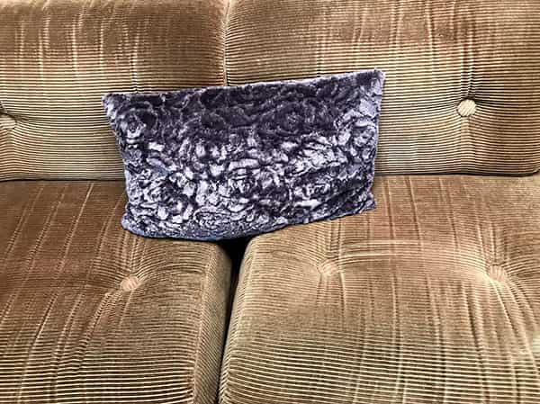 Das 1970 Parkhotel in Michelstadt-Vielbrunn hat das Design der siebziger Jahre in seinen Raeumlichkeiten eingefroren. Dieses iPhone 7 Foto entstand waerend der Filmaufnahmen zum Aldi Preis Musikvideo 2019. Zu sehen ist ein Segment eines Sofas aus den Siebzigern, die Sitzflaeche und die Rueckenlehne sind im Anschnitt. Je zwei Segmente sind abgebildet. Die Farbe des Sofas ist ein verwaschenes helles braun. Auf dem Cordsofa drapiert befindet sich ein Kissen mit einer psychedelischen Musterung. Die wolkige Struktur erstrahlt in tiefvioletter Farbe, die von hellen bis weissen Wolken durchsetzt ist.